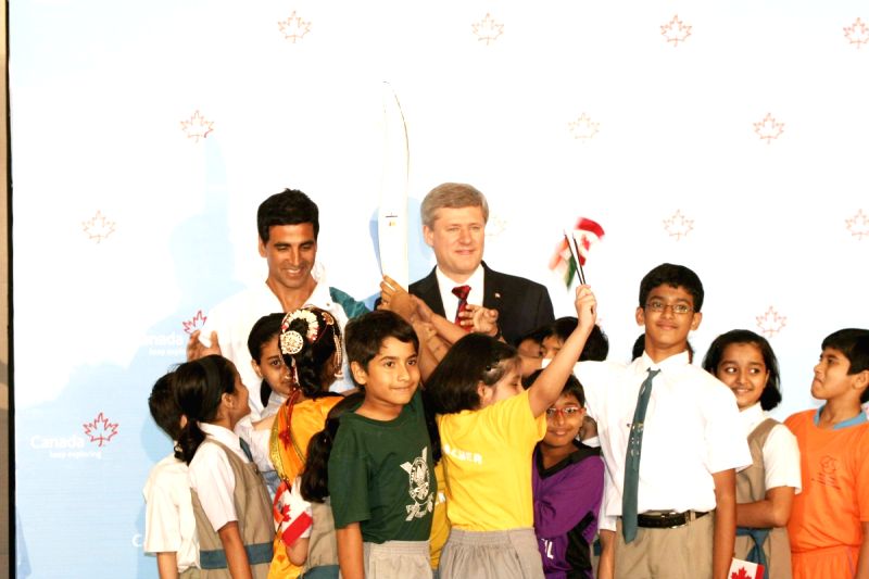 Canadian Prime Minister Stephen Harper and Bollywood Actor Akshay Kumar pose with a jacket, which will be worn by torchbearers for the 2010 Winter Olympics torch relay during an event at Trident in Mumbai on Monday, 16 November 2009.