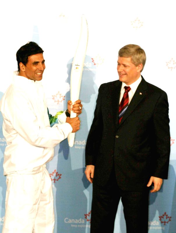 Canadian Prime Minister Stephen Harper and Bollywood Actor Akshay Kumar pose with a jacket, which will be worn by torchbearers for the 2010 Winter Olympics torch relay during an event at Trident in Mumbai on Monday, 16 November 2009.