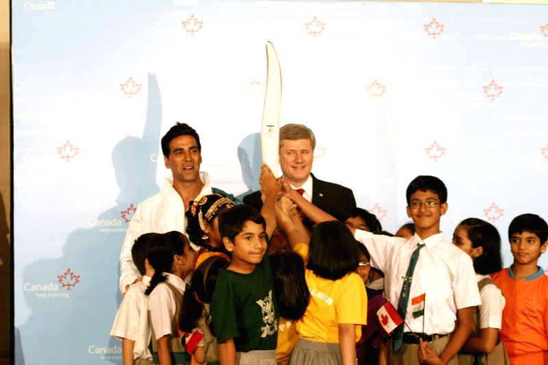 Canadian Prime Minister Stephen Harper and Bollywood Actor Akshay Kumar pose with a jacket, which will be worn by torchbearers for the 2010 Winter Olympics torch relay during an event at Trident in Mumbai on Monday, 16 November 2009.