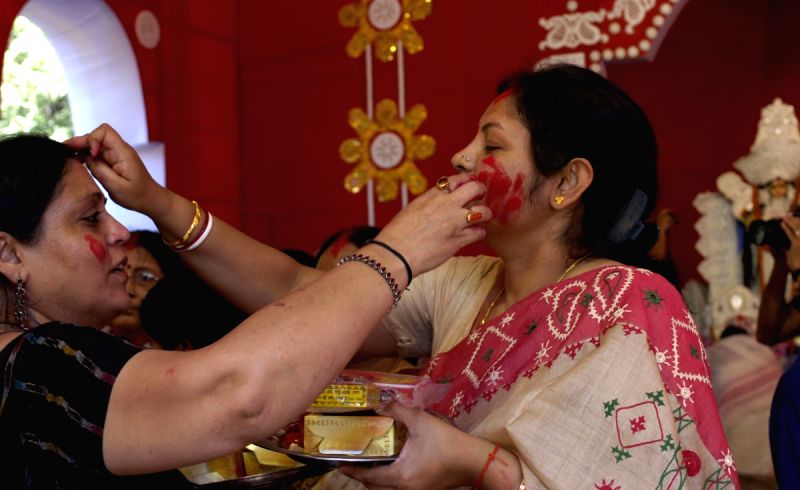 Ladies applying Vermilon after the end of Dasami at a puja pandal in East Delhi on Monday 28th September 2009. (Photo: Partha Sarkar, IANS)