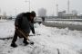A local clearing snow from the road in Srinagar.