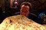 Arnold Schwarzenegger eating a huge naan especially created for him