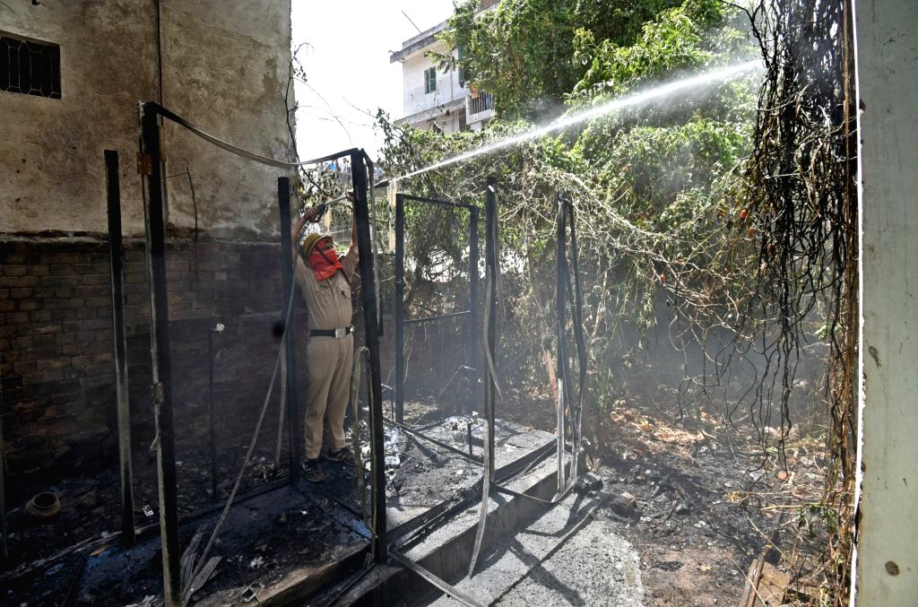A Firefighter trying to douse a fire as it broke out after a LPG ...