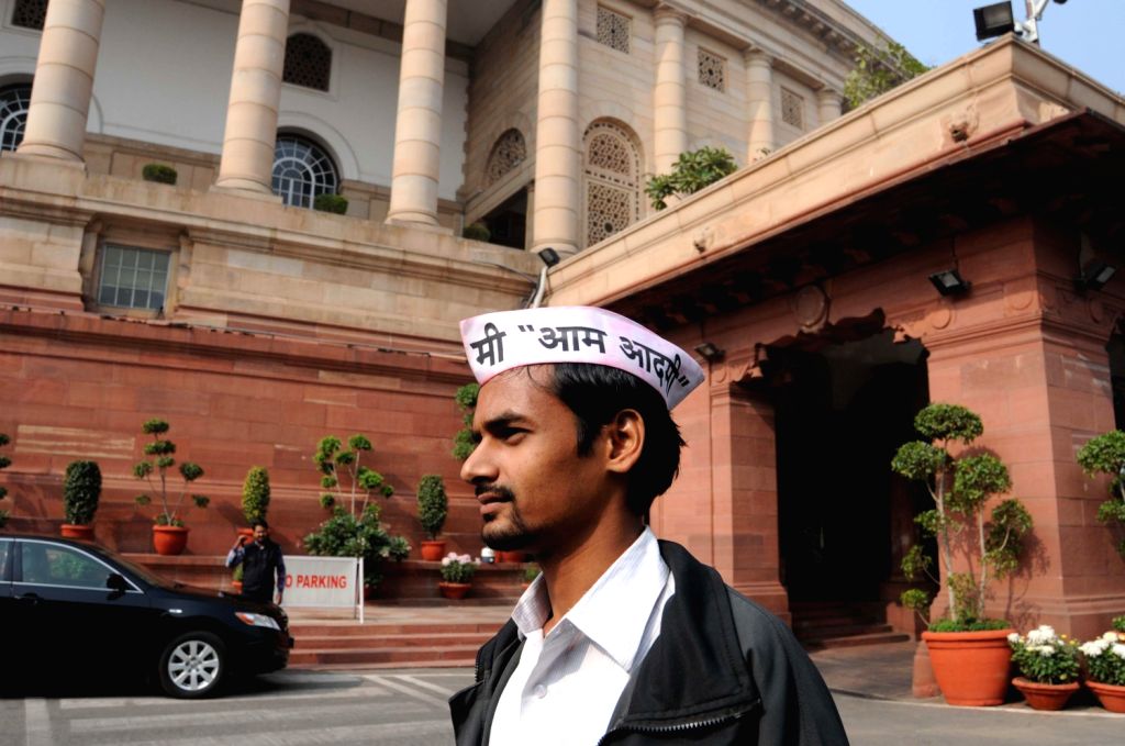 A man wears AAP cap outside the parliament