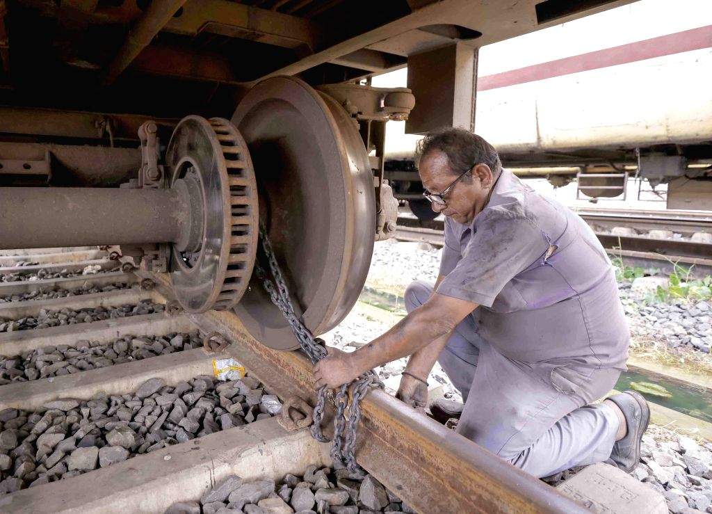 A Railway Maintenance Worker ties the train with chain lock at Shalimar ...