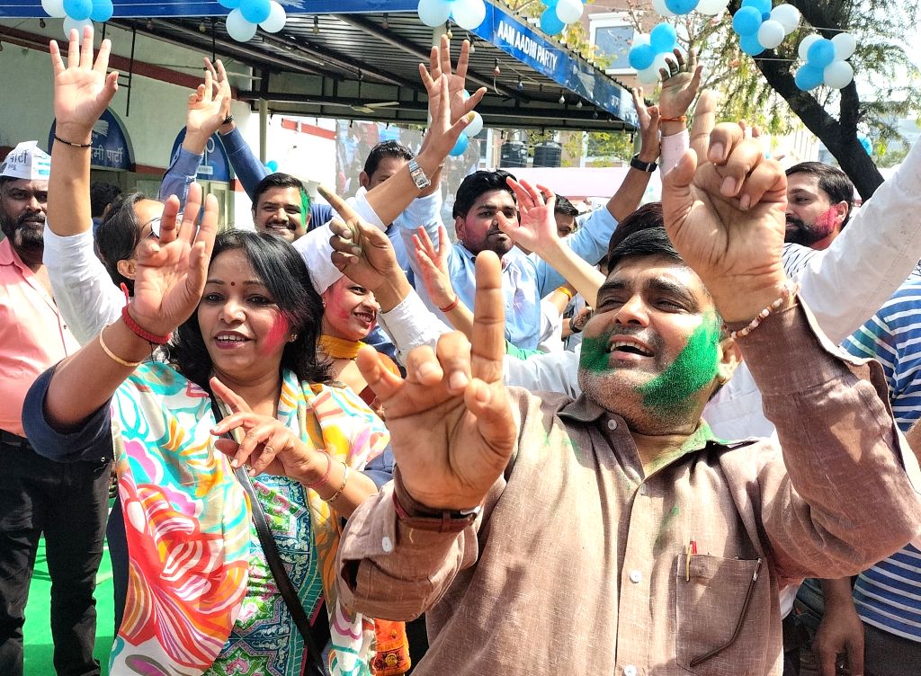 AAP supporters celebrate with color as party leads in assembly polls