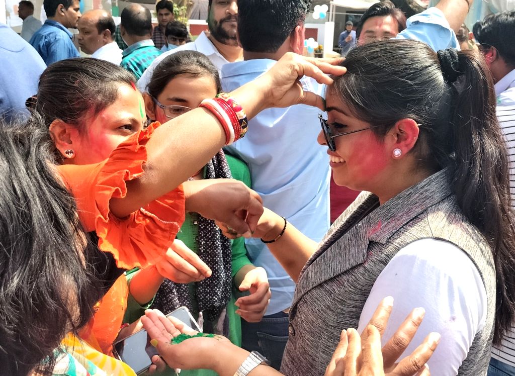 AAP supporters celebrate with color as party leads in assembly polls