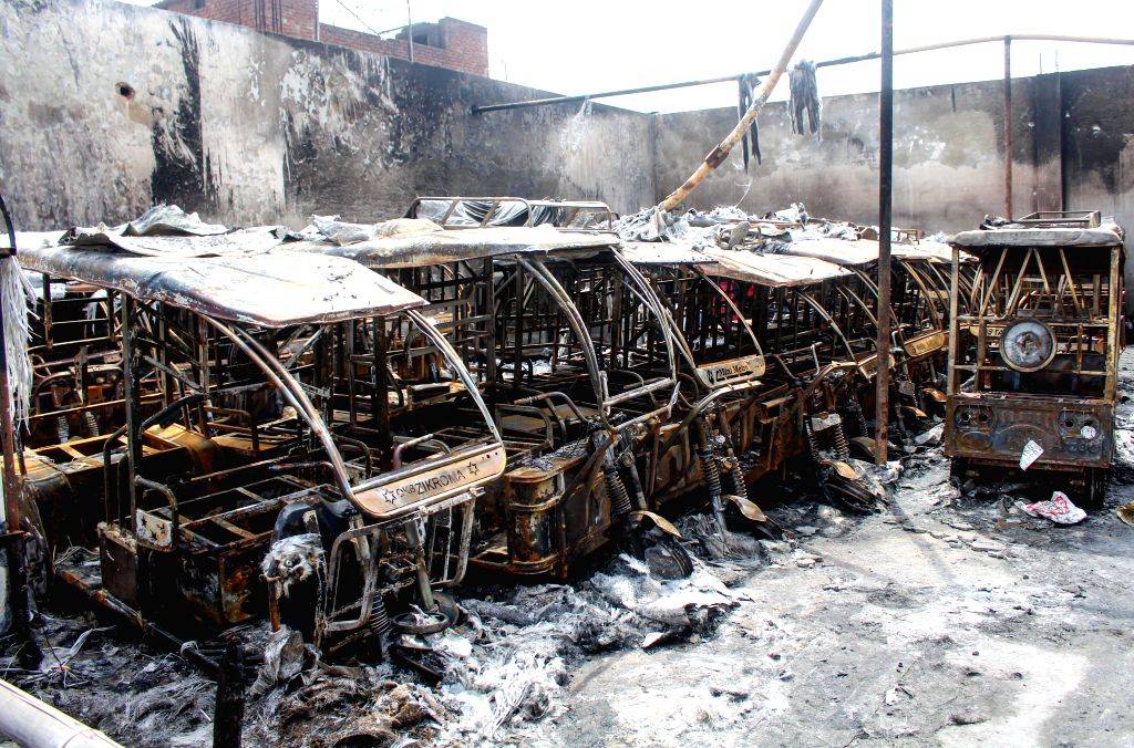 Charred e-rickshaws after a massive fire at a charging station