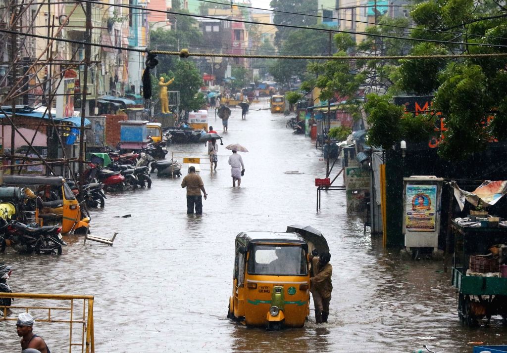 Commuters wade through flooded roads.