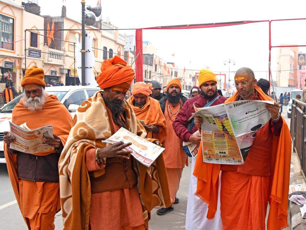 Devotees read newspapers on a road ahead of the Ram temple consecration ...