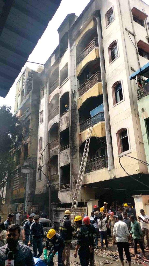 Firefighters and police personnel at the site after a fire broke out at ...