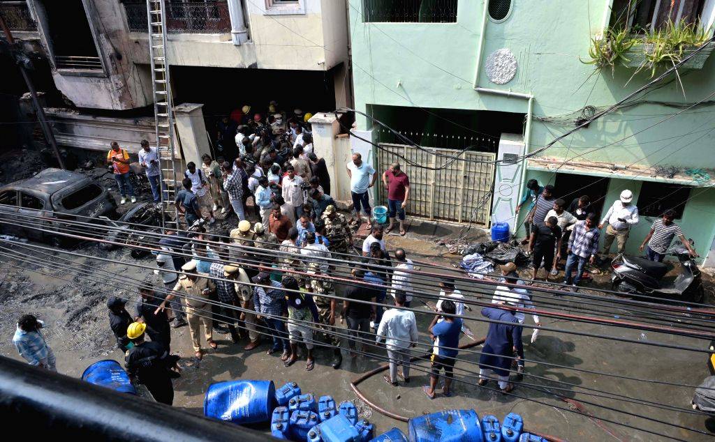 Firefighters and police personnel at the site after a fire broke out at ...