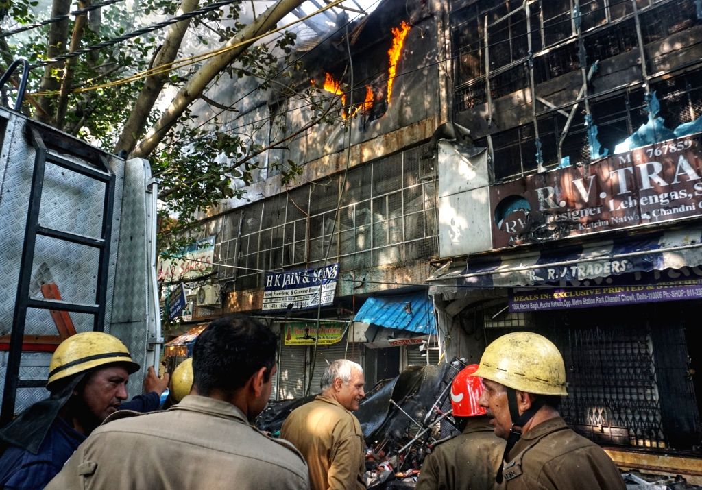 Firefighters douse fire after it broke out at a cloth shop