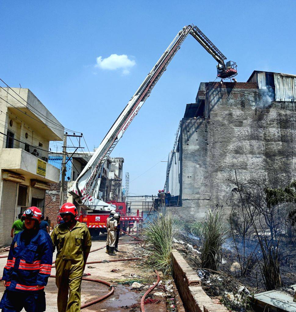 Firefighters try to douse a fire after it breaks out at a factory in ...