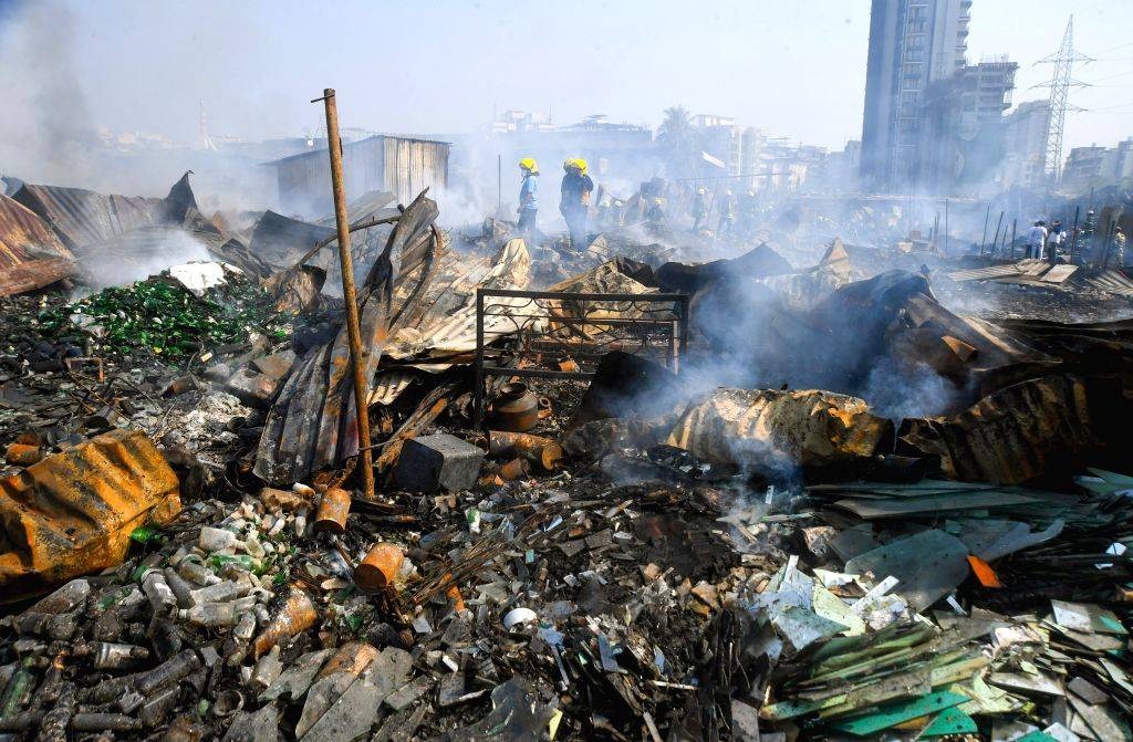 Firefighters trying to douse fire after a fire broke out in a slum