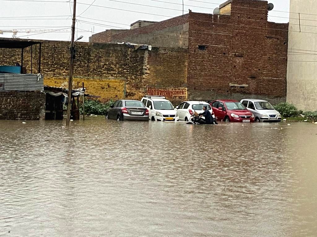 Free Photo: New Delhi: Heavy rain throws life out of gear in Gurugram ...