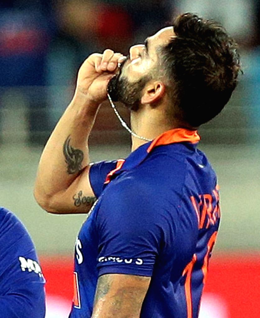 DubaiIndia's Virat Kohli,kisses the locket after scoring a century.