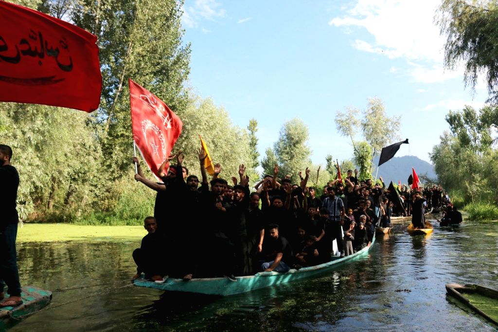 Kashmiri Shiite Muslims shout religious slogans as they ride on boats