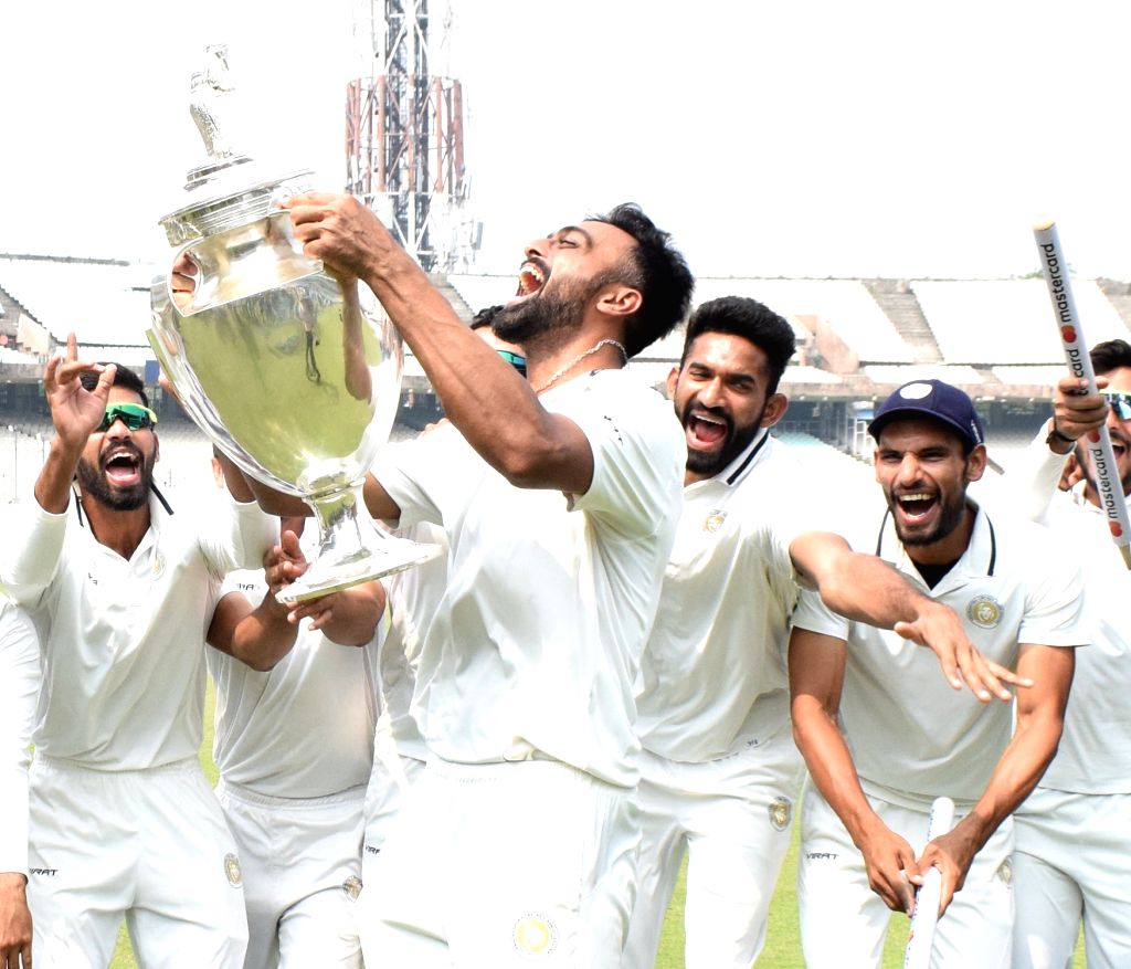 :Kolkata: Saurashtra captain Jaydev Unadkat hold the trophy as he ...