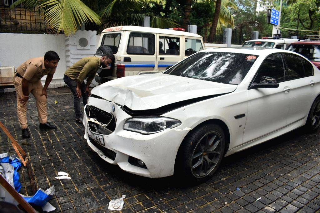 Mumbai : Police personnel inspect a BMW car that ran over two people ...