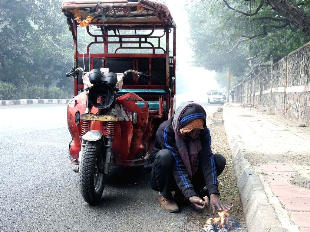 Fire Rickshaw : New Delhi : An E-Rickshaw driver warming himself by setting fire to ...