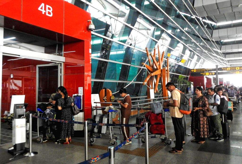Passengers stand in a queue as they wait due to delays in airline ...