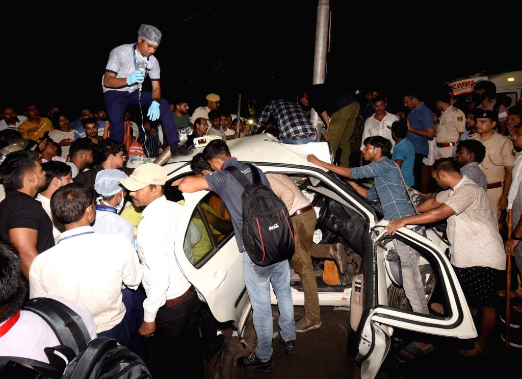 People attempt to rescue injured after a collision between two cars