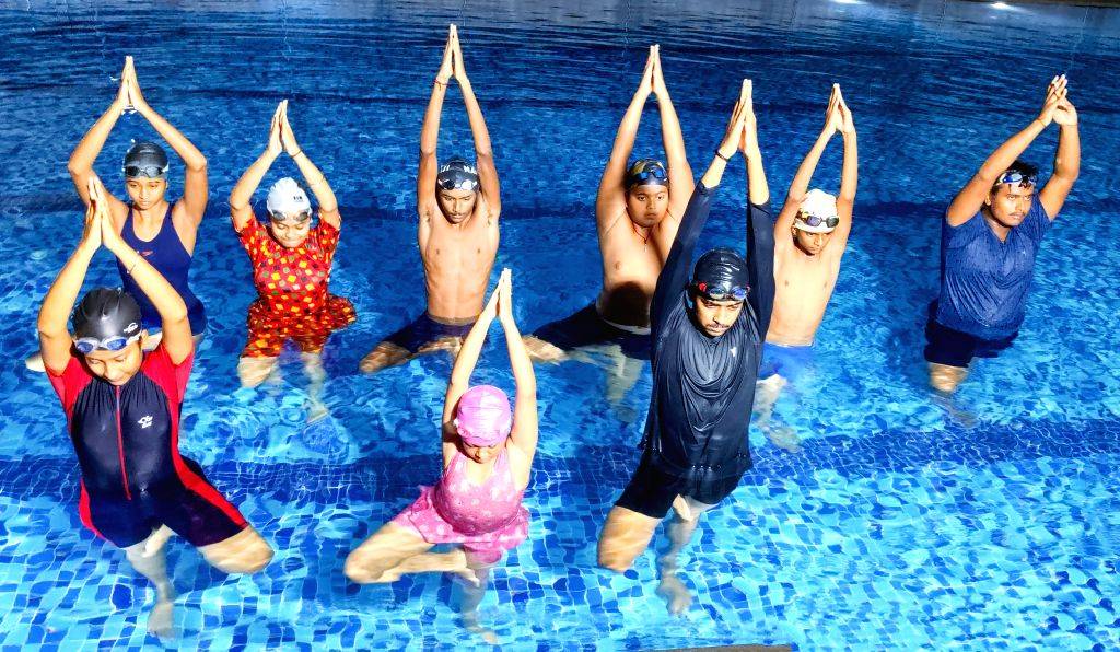 Pool Yoga Fun People perform yoga in a swimming pool