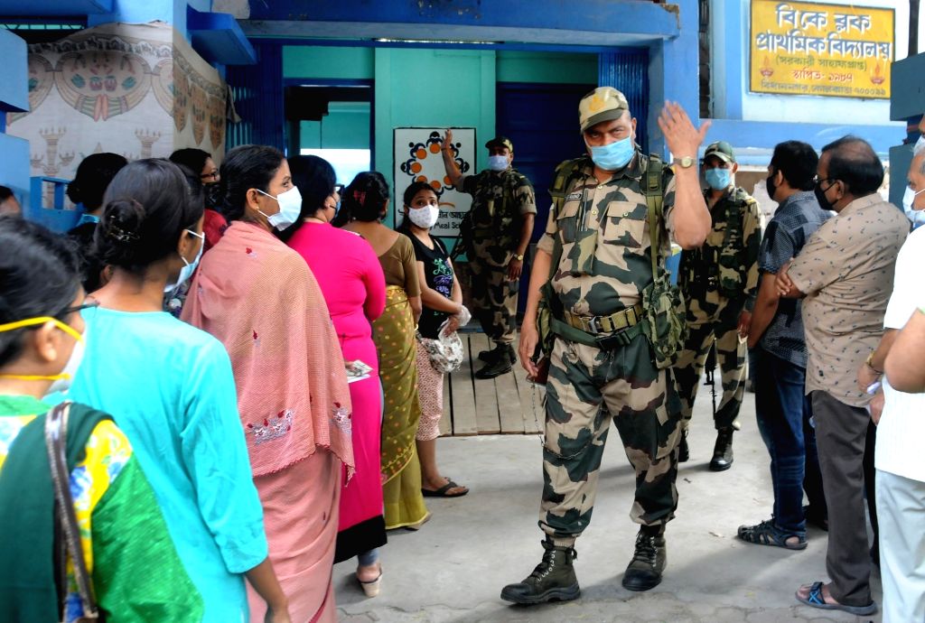 People stand in a queue at a polling station to cast their vote during ...