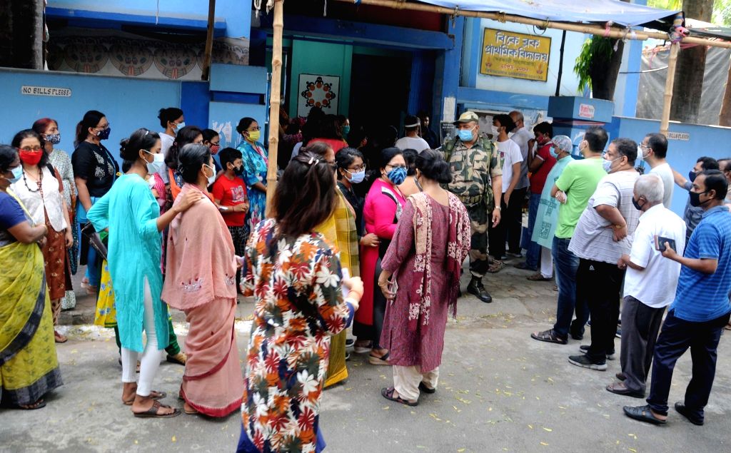 People stand in a queue at a polling station to cast their vote during ...