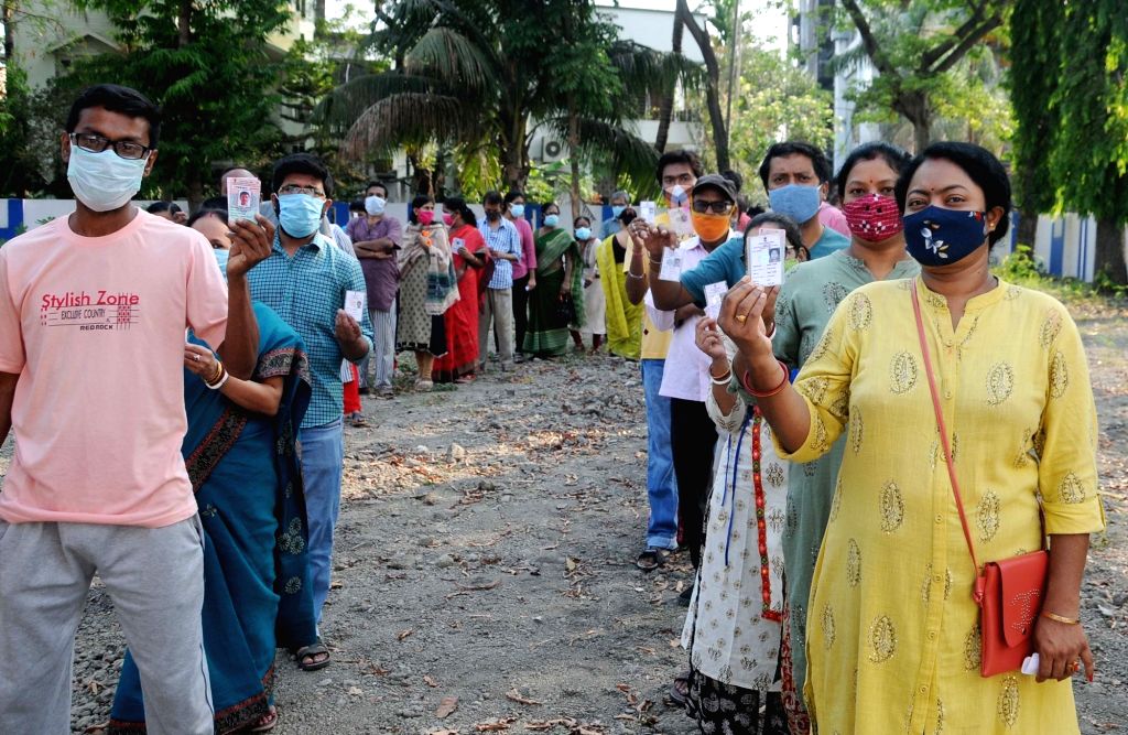 People stand in a queue at a polling station to cast their vote during ...
