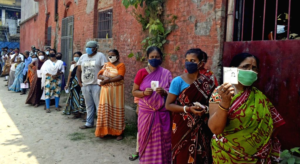 People stand in a queue at a polling station to cast their vote at ...