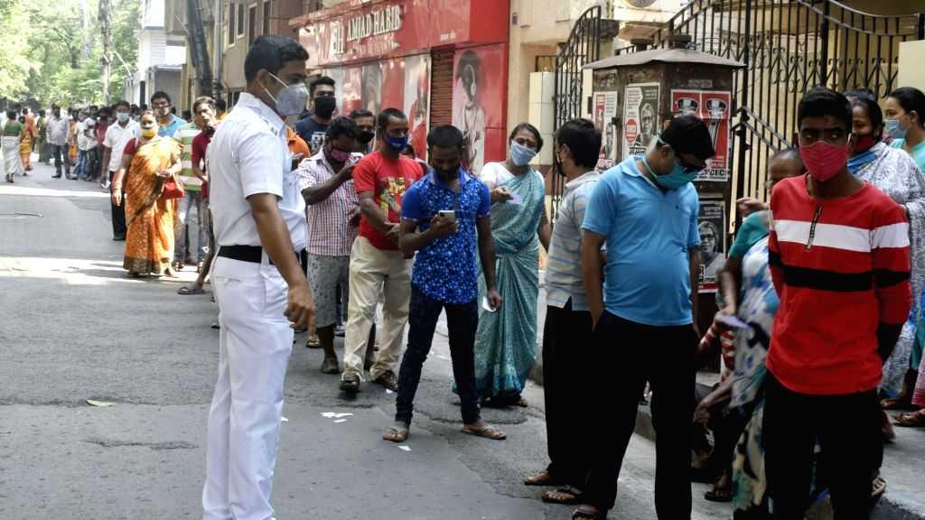 People stand in a queue at a polling station to cast their vote at ...