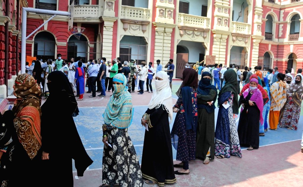 People stand in a queue at a polling station to cast their vote during ...