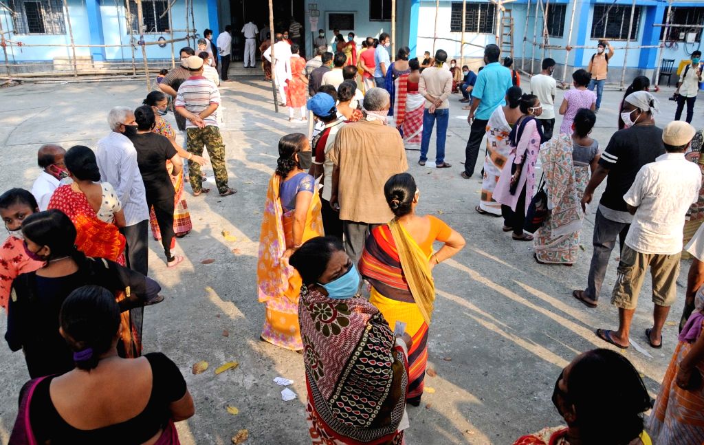 People stand in a queue at a polling station to cast their vote during ...