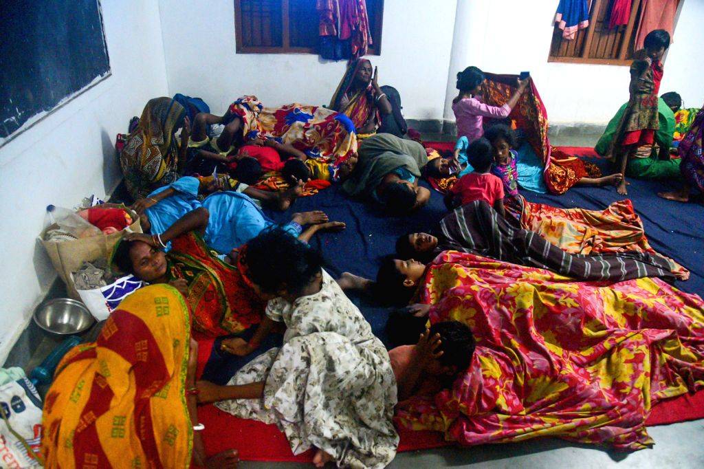 People take shelter in a cyclone centre ahead of Cyclone Dana's landfall