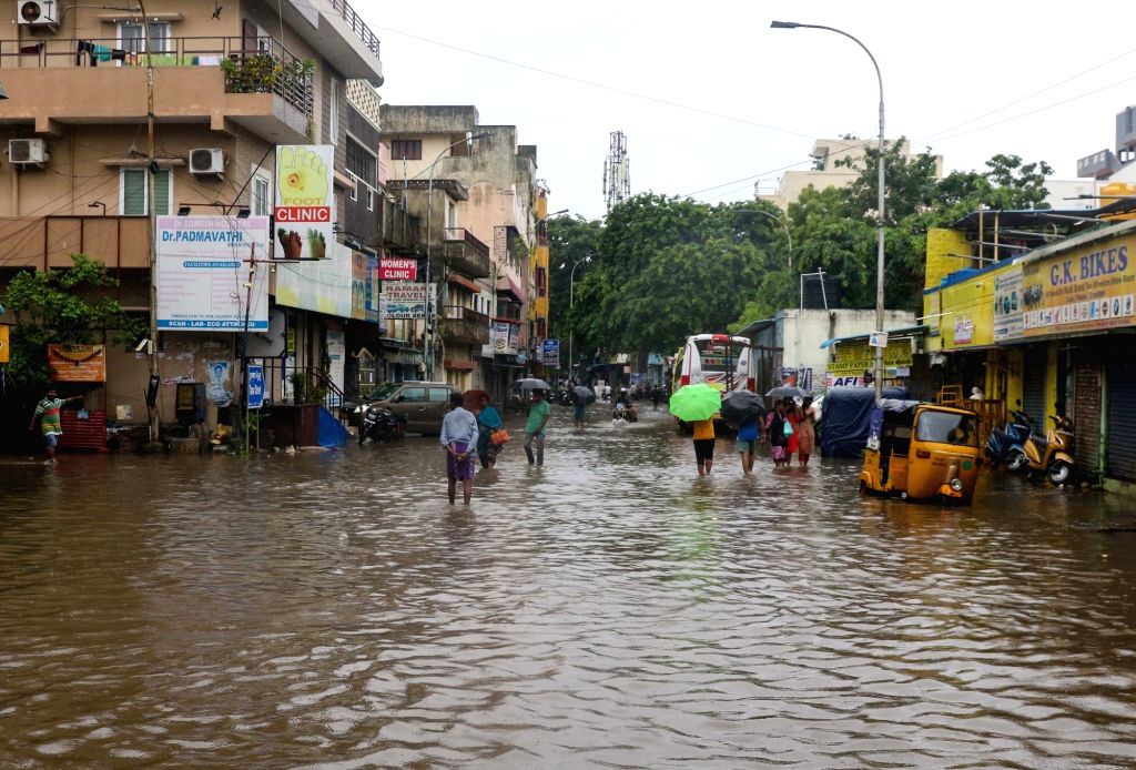 People wade through flooded roads.