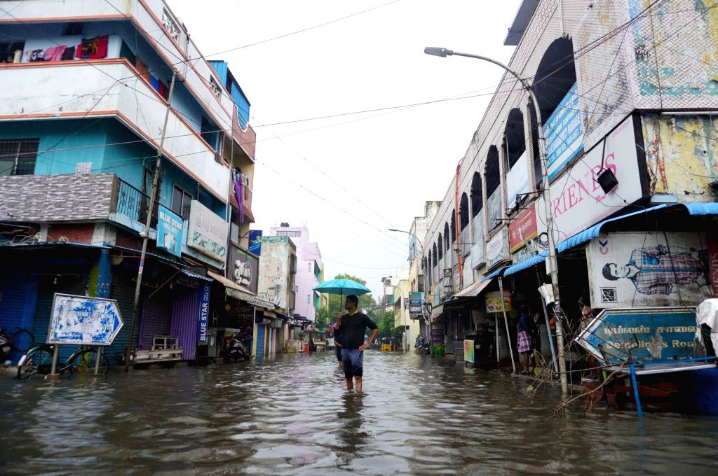 : Chennai:People wade through submerged street during heavy rainfall