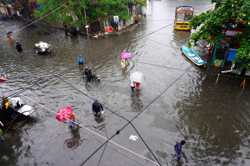 : Chennai:People wade through submerged street during heavy rainfall