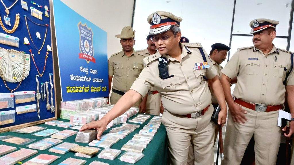 Police Commissioner B Dayananda examines the confiscated cash and jewels