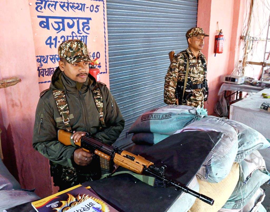 Security personnel stand guard outside a strong room where EVMs are kept