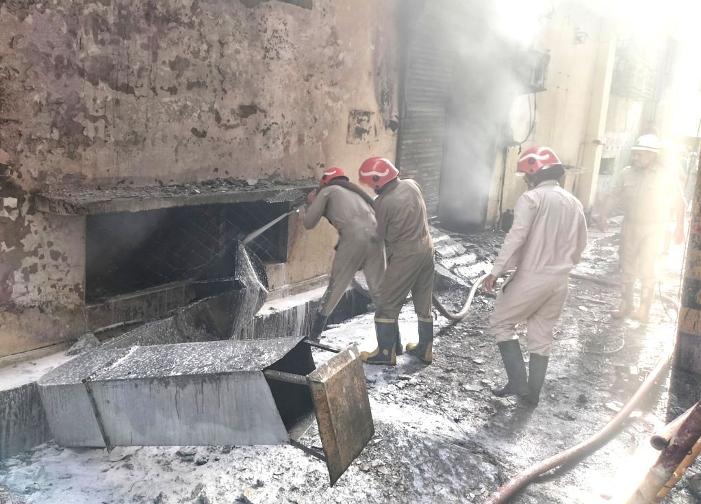 New Delhi : Smoke billows as firefighters try to douse a fire at a showroom
