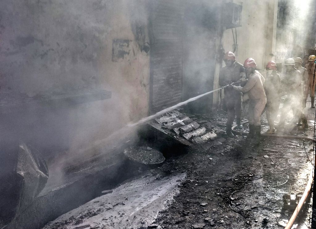 New Delhi : Smoke billows as firefighters try to douse a fire at a showroom