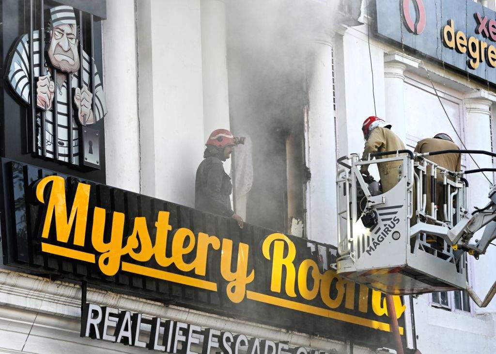 Smoke billows as firefighters try to douse a fire after it breaks out ...