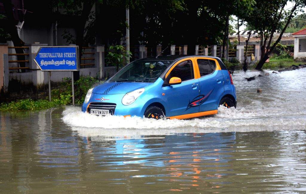 Vehicles navigate a waterlogged road after heavy rainfall