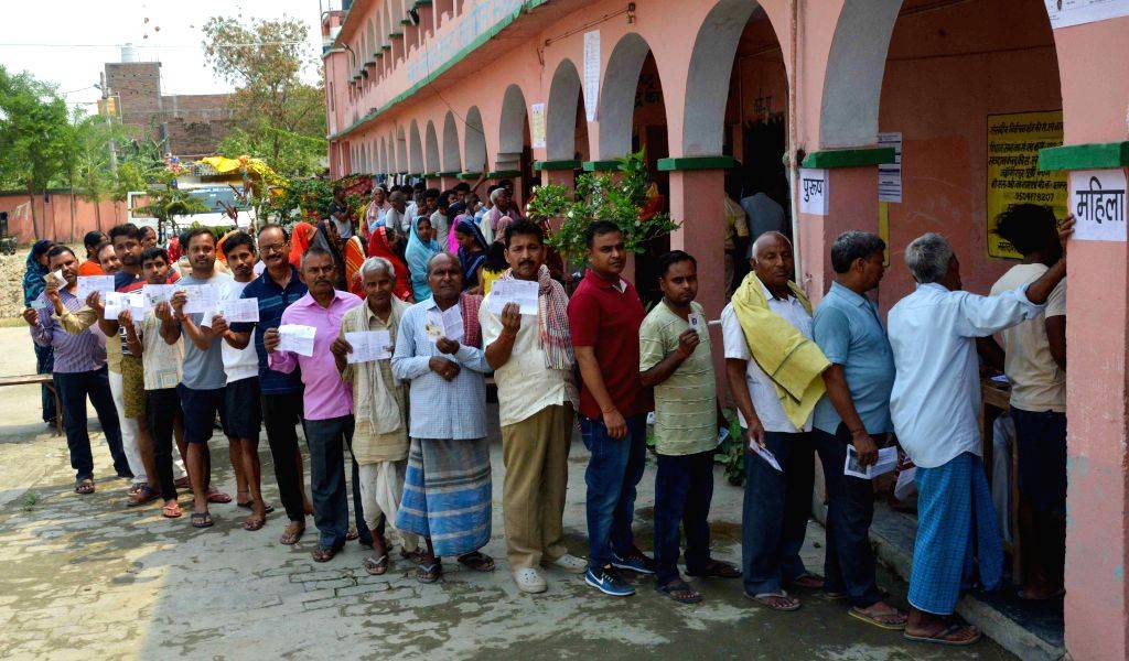 Voters stand in a queue to cast their vote at a polling booth during ...