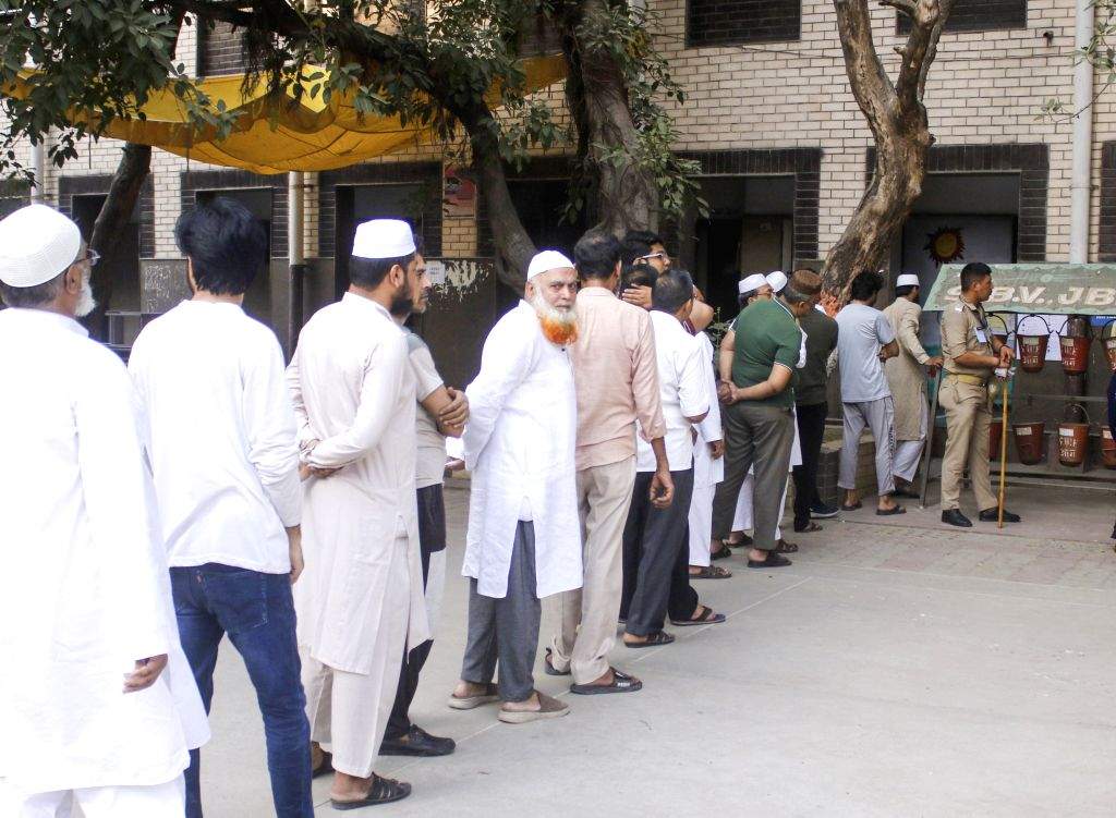 Voters stand in a queue to cast their vote in the sixth phase of the ...