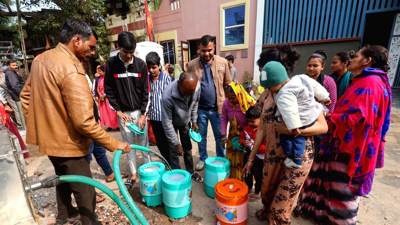 Residents collect clean drinking water from a tanker